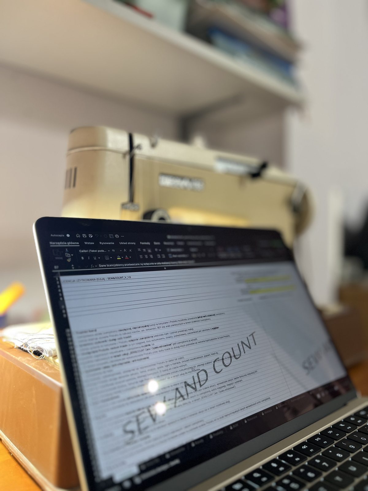 Arkusz SEW AND COUNT otwarty na laptopie z maszyną do szycia w tle